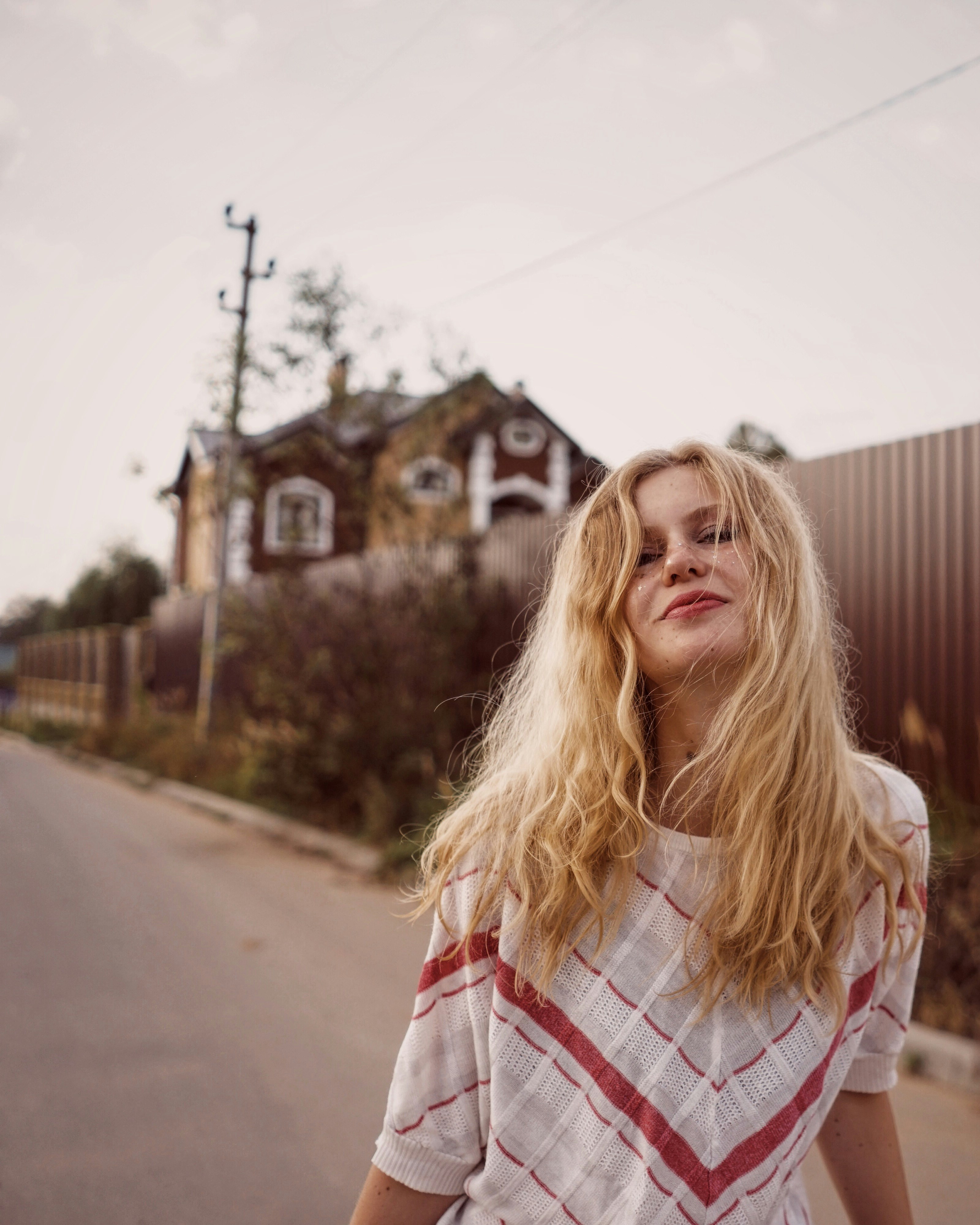 smiling woman standing on road near wall